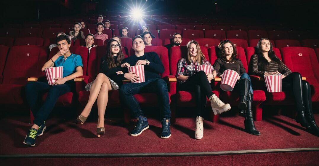 People at the cinema watching a movie with famous French actors