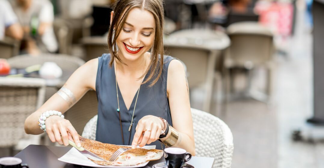 Woman eating a crêpes - one of the most famous French meals