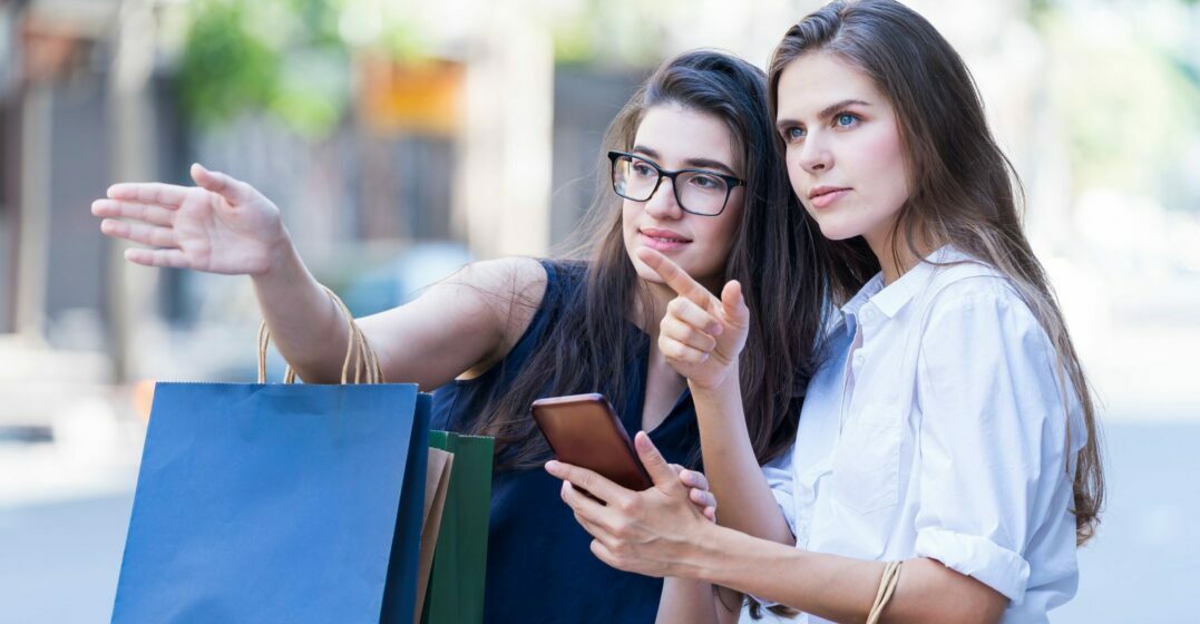 Young woman giving directions in German to another woman on the street