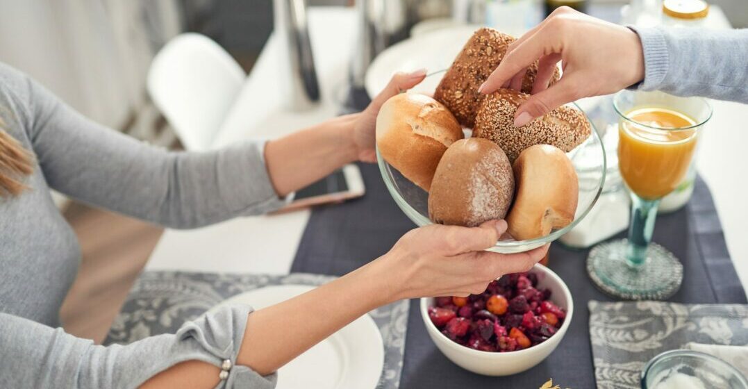 a person holding bread rools which makes a typical german breakfast