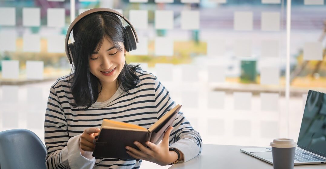 Junge Frau mit einem Buch liest englische Kurzgeschichten für Anfänger