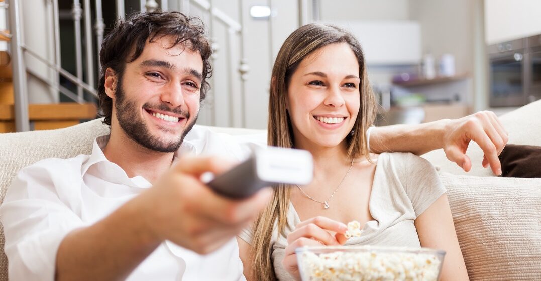 A happy couple going through French TV channels