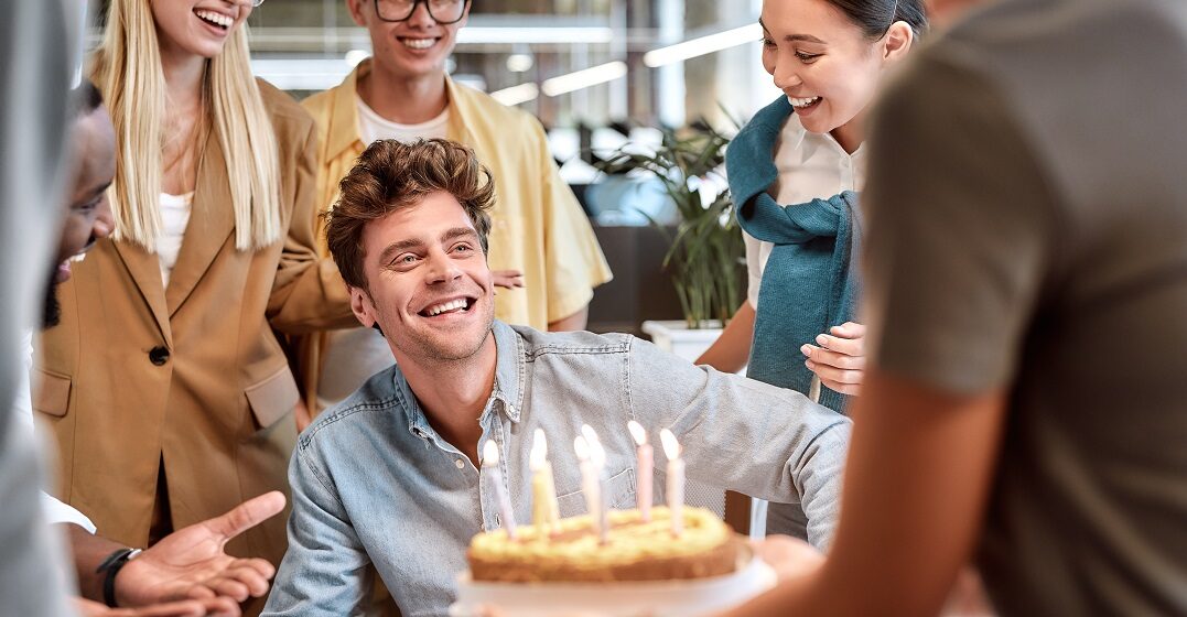 Young man receiving a birthday cabke and happy birthday wishes in German