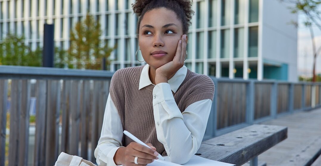 Woman writing an essay with essential essay words