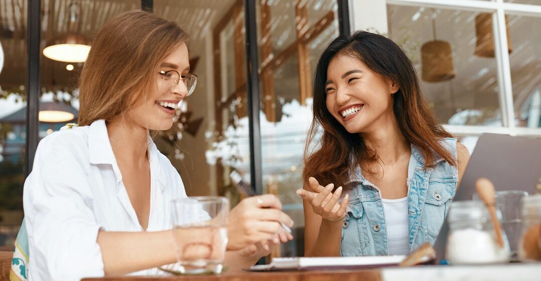 Two girlfreinds laughing about anglicisms