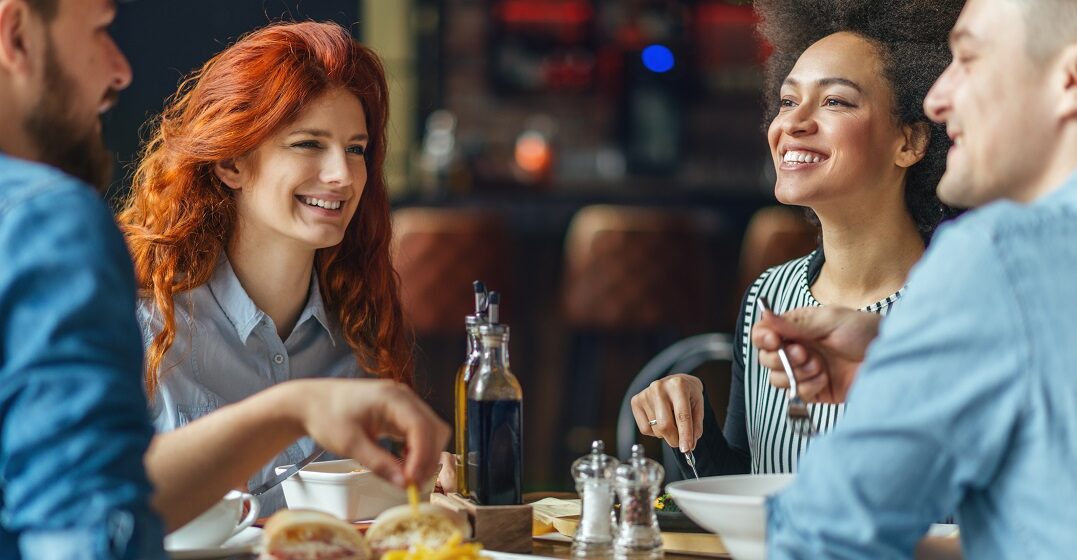 Four friends around a table discussing what language Scottish people speak