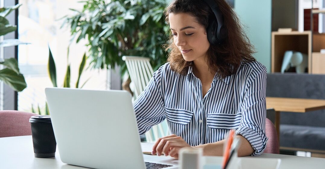 Young woman studying when to use I or me at her laptop