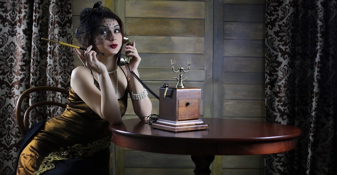 Elegant woman dressed in 1029s style with an old telephone using slang terms