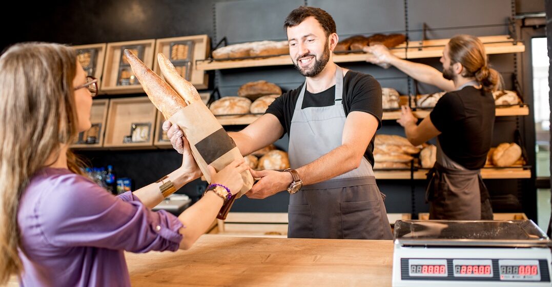 Young woman buying many types of French bread