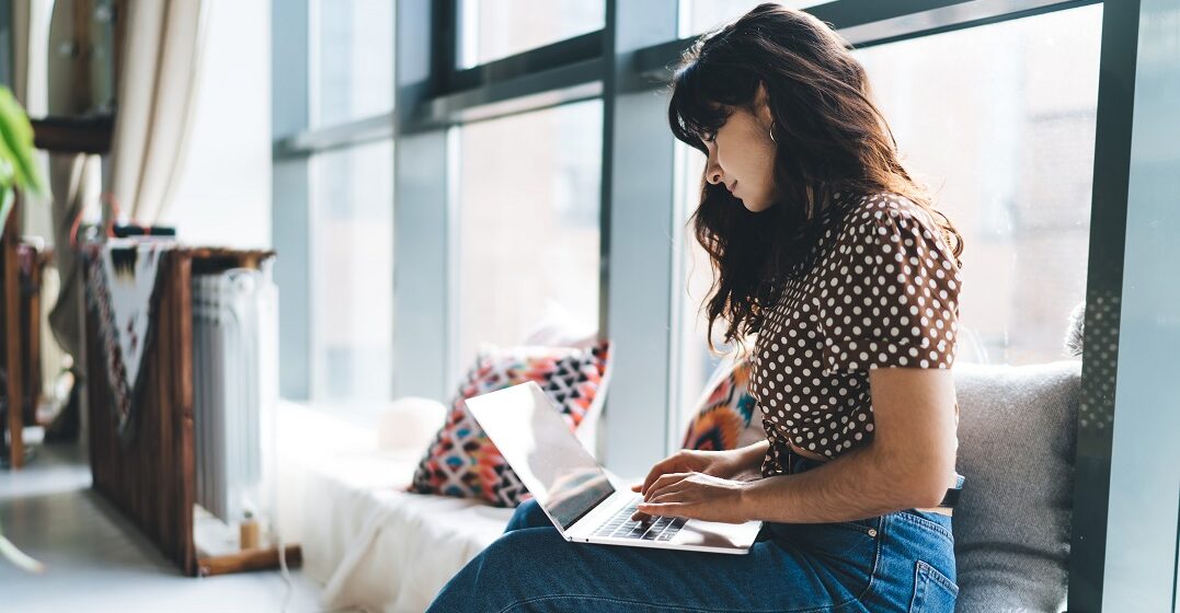 Young woman with a laptop studying the German possessive pronouns