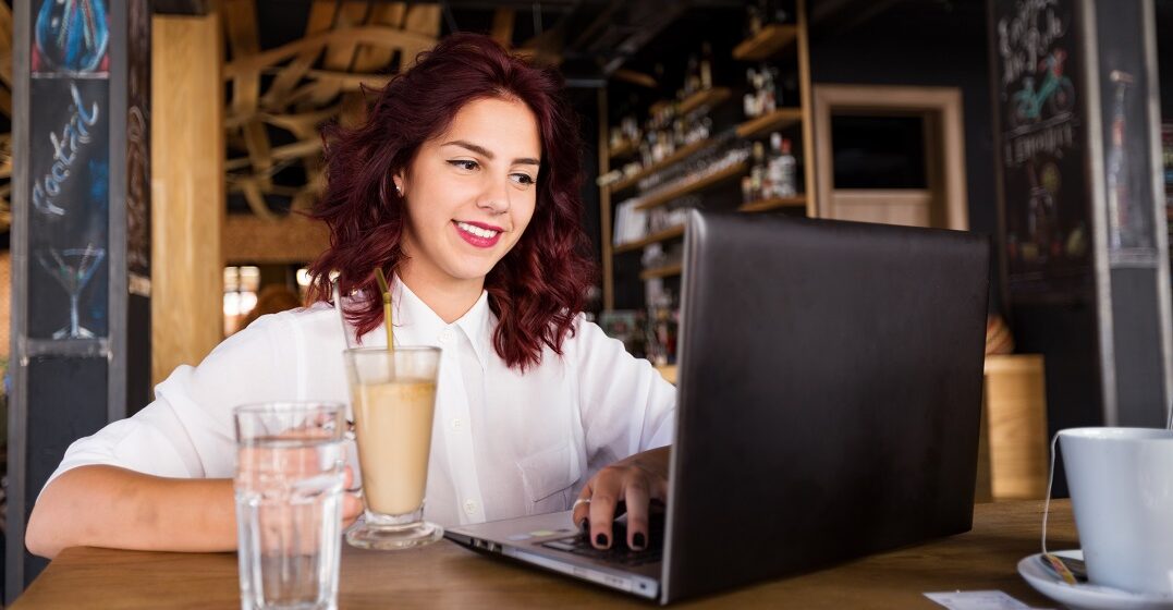Young girl at her laptop studying the demonstrative adjectives this that these those in Spanish