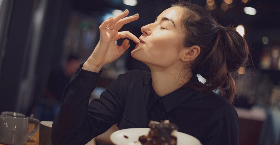 Woman eating chocolate cake and saying to like in German