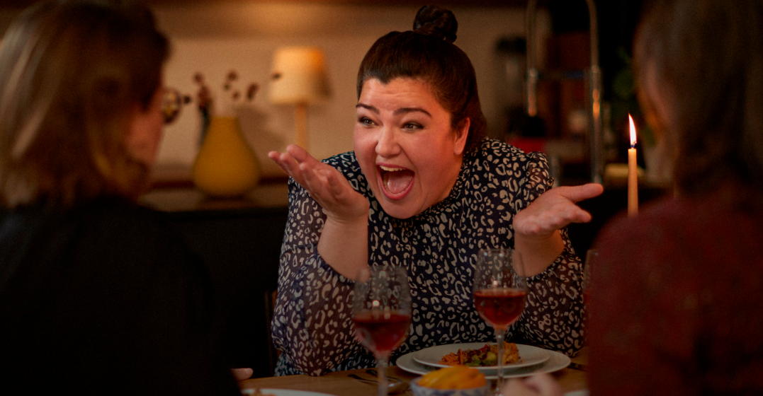 Woman with friends having dinner, celebrating her language wins