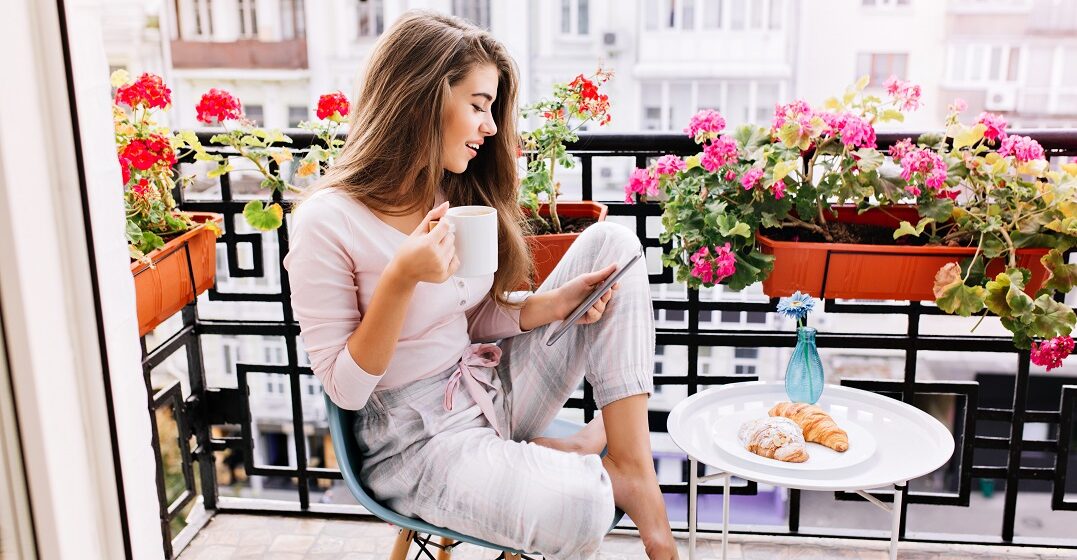 Young woman on her balcony learning beautiful French words