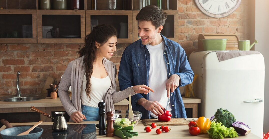 Couple cooking with kitchen utensils in French