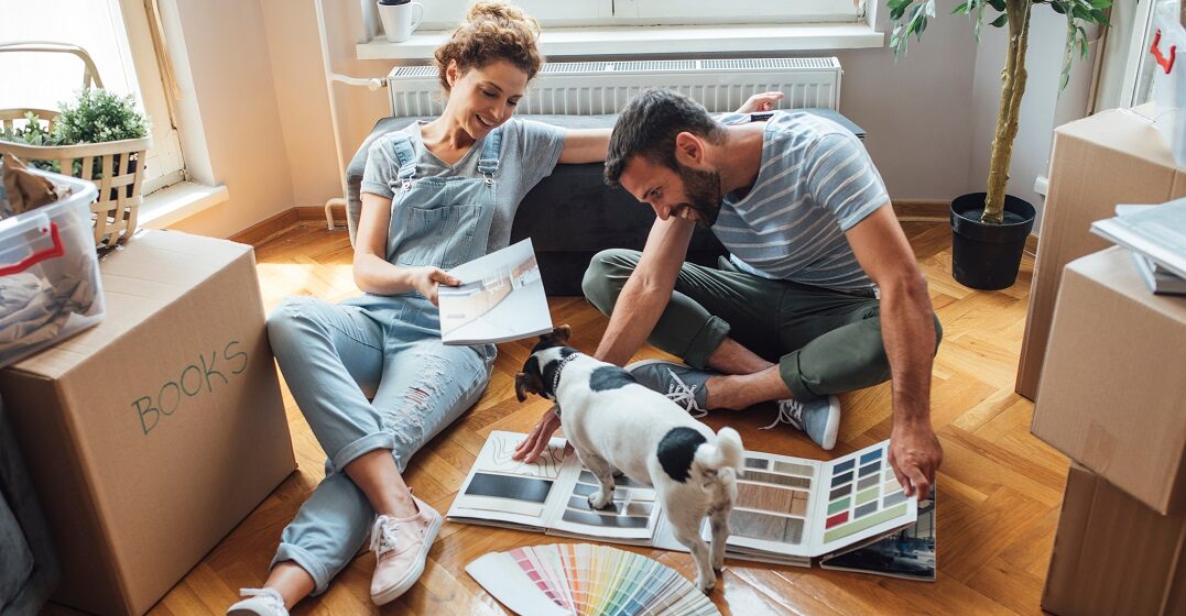 A couple choosing paint in a book for their German home they just moved in