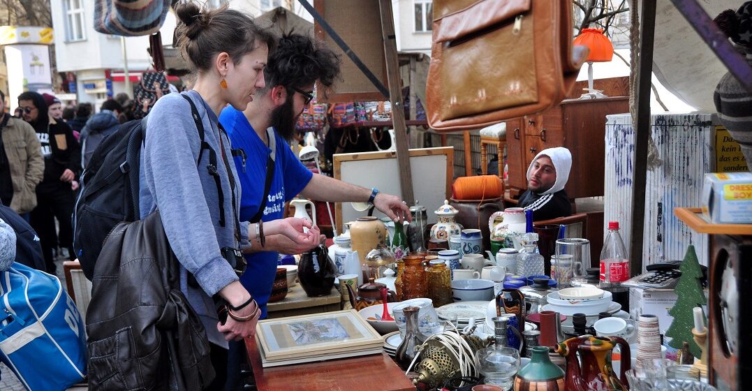 Two adults looking at a stand at a German flea market