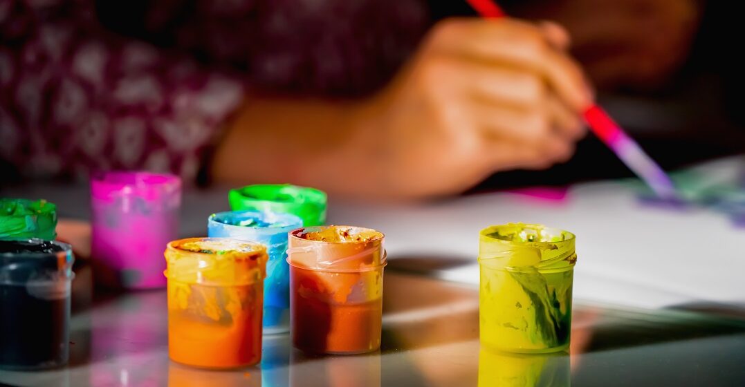 Una mano borrosa que utiliza colores acrílicos para aprender su nombre y pronunciación
