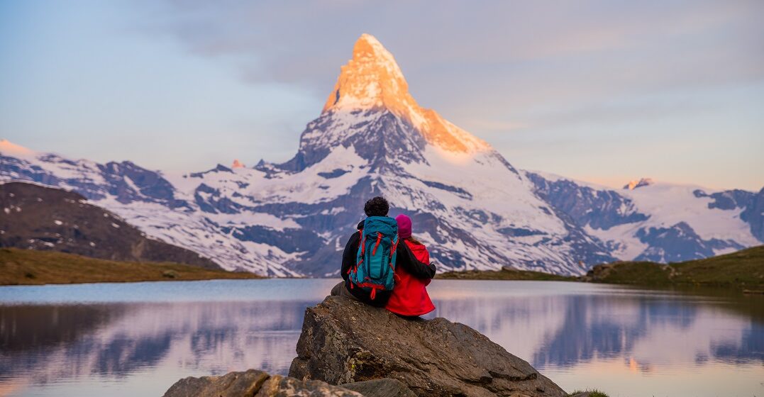 Couple watching the sunset in the mountains of Switzerland, enjoying the high quality of life there