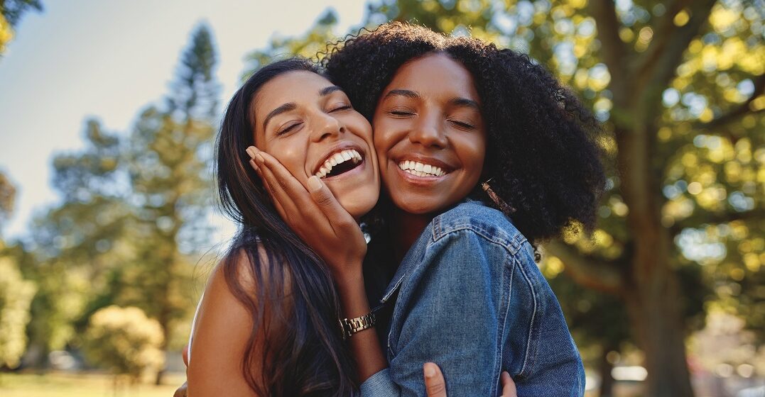 Portrait of two young women hugging and saying thank you to each other in Spanish