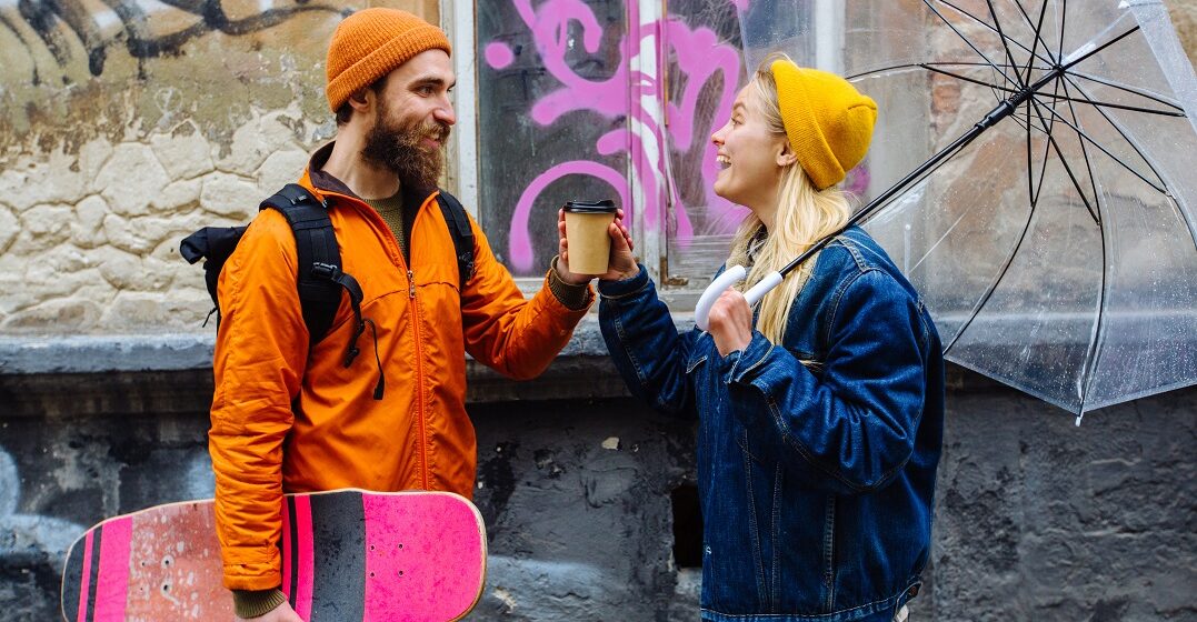 Two hipsters in second hand clothes drinking coffee in Berlin