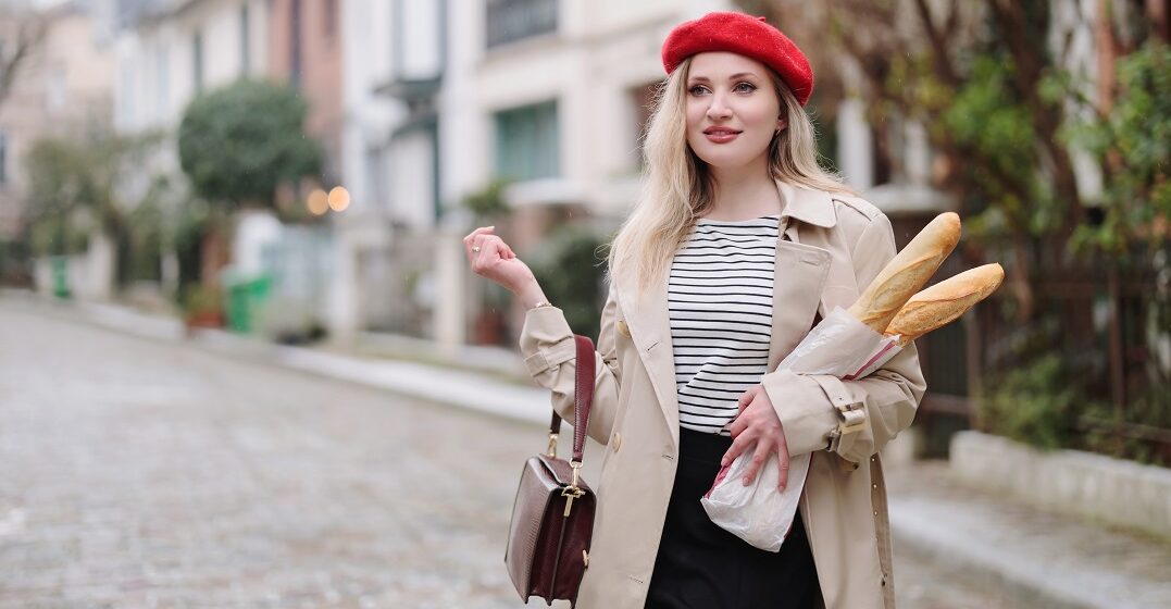 Blod girl holding baguettes and wearing a beret, two very French cliches