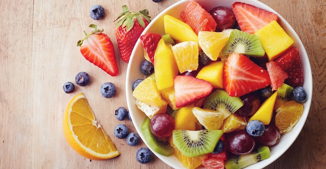 Bowl of fruits on a wooden table that people will learn to say in German