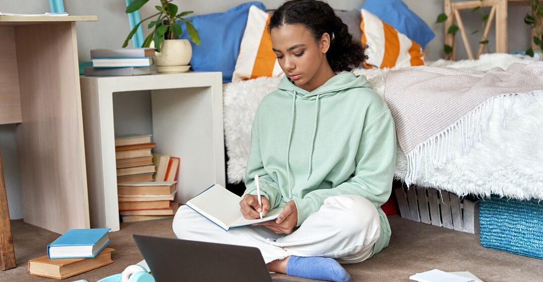 Chavala estudiando en su portatil cuáles son las preposiciones de lugar en inglés