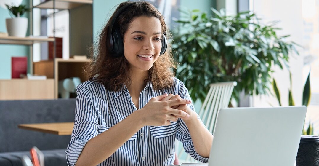 Young woman sits at her laütop taking an online course about superlatives and comparatives in German