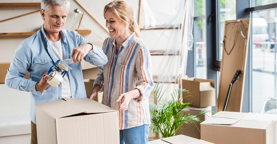Life in Switzerland: A guide for expats Senior couple boxing things up in their house before relocating