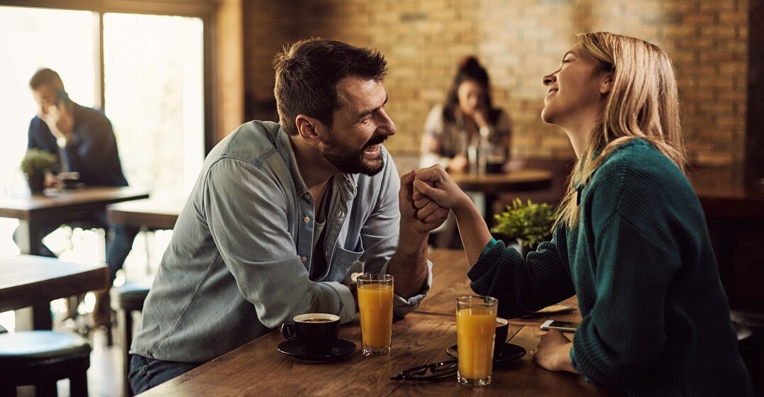 Happy,Man,Flirting in Spanish ,With,His,Girlfriend,While,Holding,Her,Hand