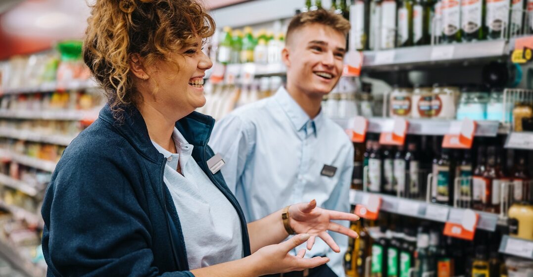 A supermarket manager and an minijob employee in Germany in front of the shelves