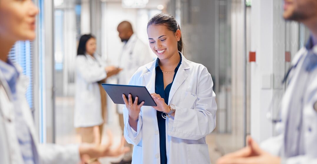 Happy woman doctor on tablet in a German hpspital