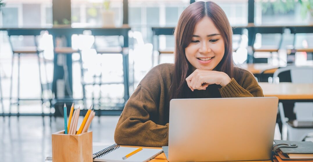 Junge asiatische Frau lernt die Modalpartikeln an ihrem Laptop