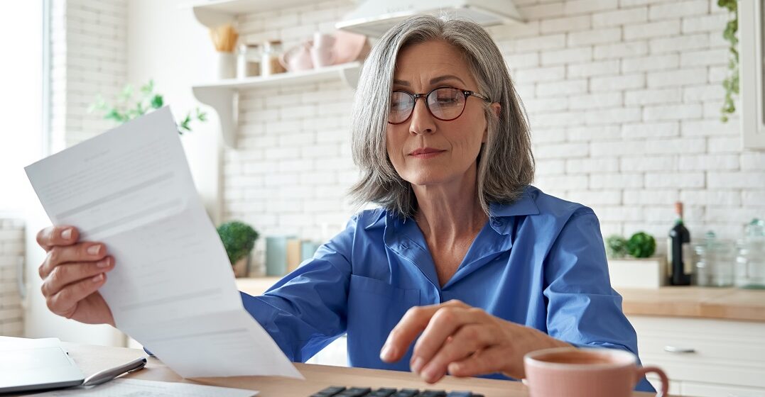Senior checking papaers to claim her pension in Germany as a foreigner