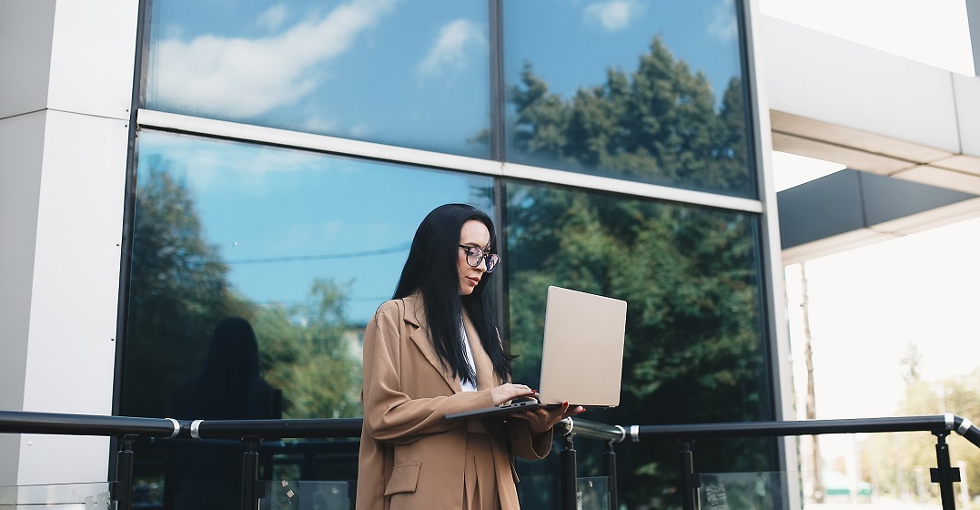 Young business woman researching the unemployment benefits in Switzerland at her laptop
