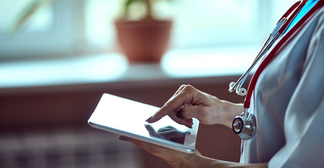 Eine Ärztin im Gesundheitssystem der Schweiz tippt auf ihrem iPad