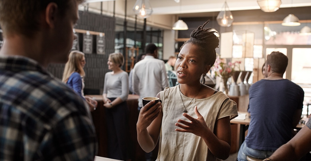 An African woman describing a person in German to someone else