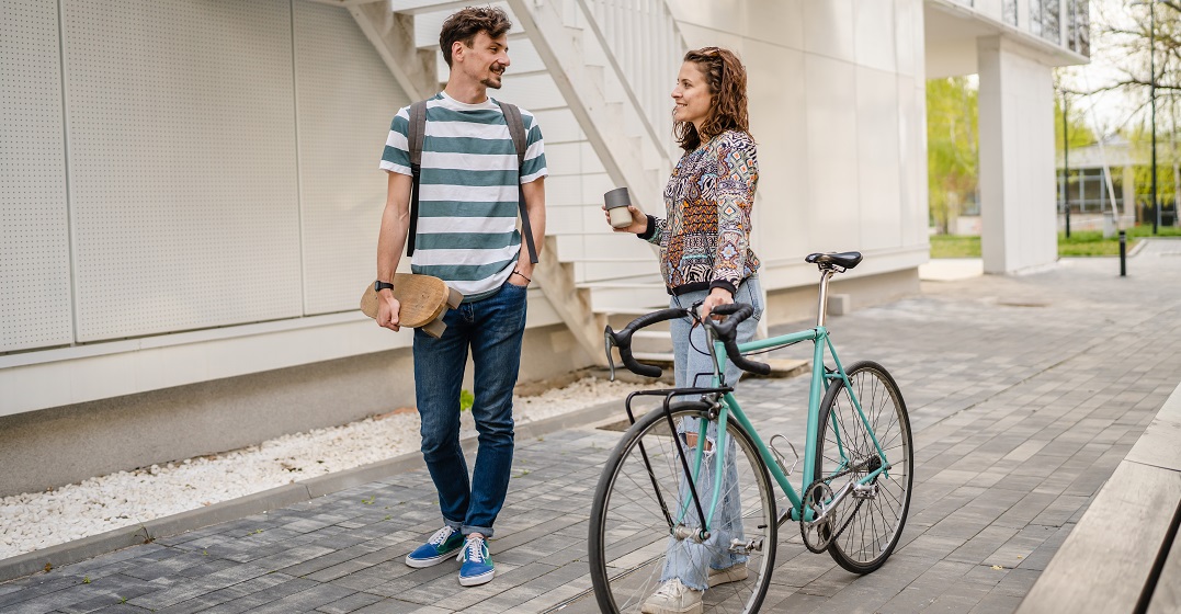 A young woman with a bike talking to a male friend using Swisss German phrases