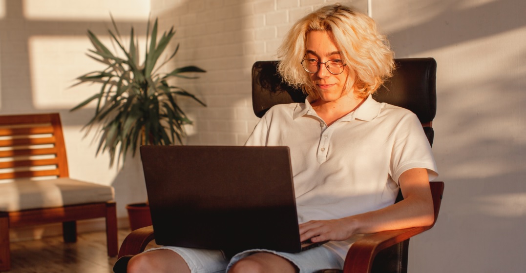 Young man with blonde hair sitting at his laptop studying the German conjunctions