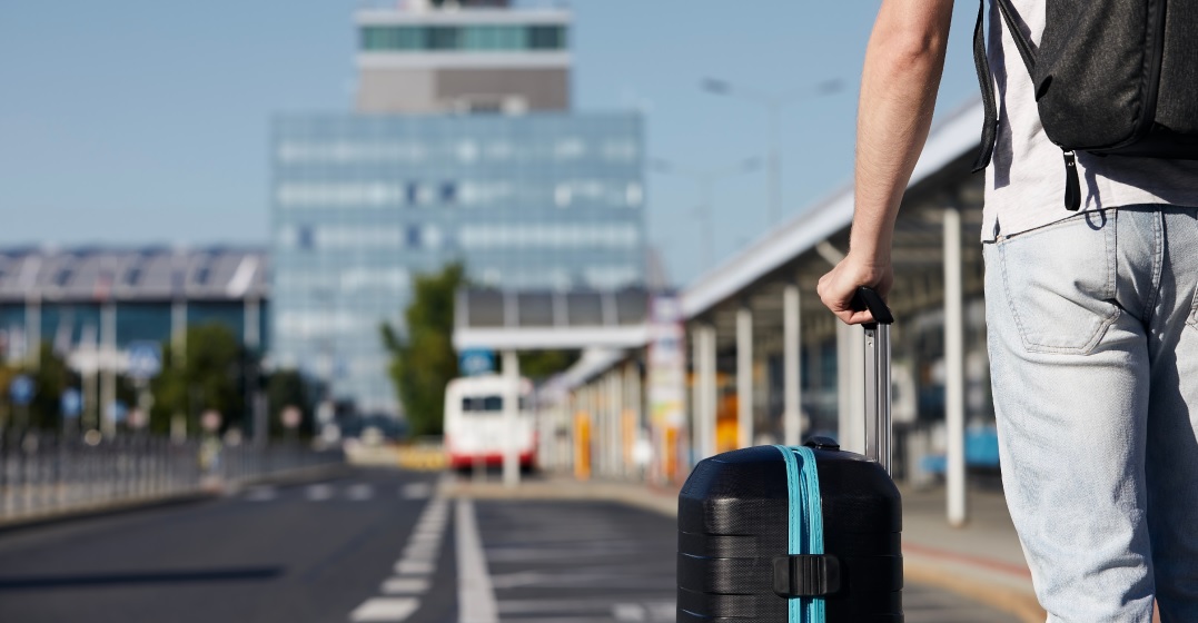 Passenger walking from bus station to airport terminal after having deregistered in Germany