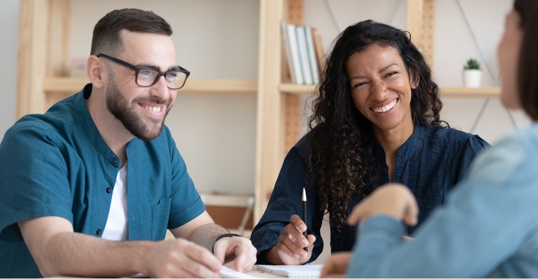 Two smiling people in a job interview discussing if they want to go with