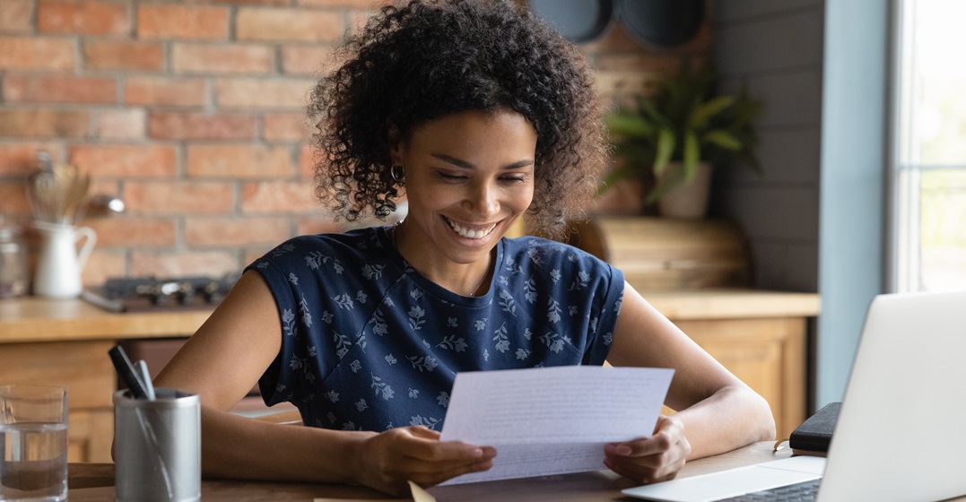 Smiling woman looking at her German language certificate