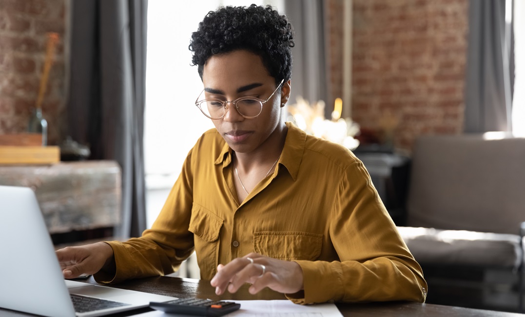 Afro-American woman typing on a calculator studying the German ordinal numbers