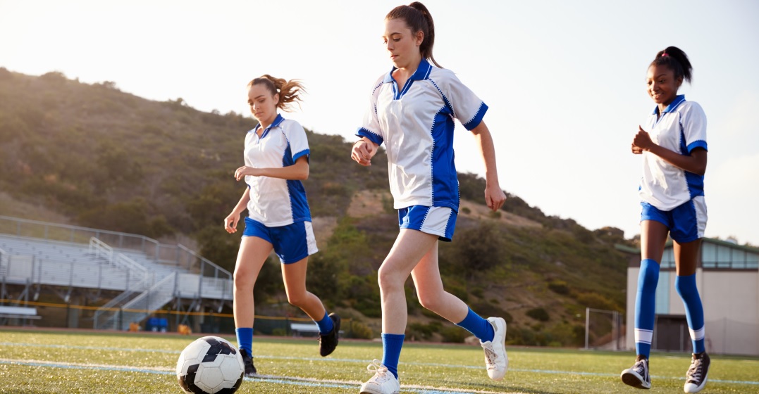 Three young women playing football - one of Germany's most popular sports