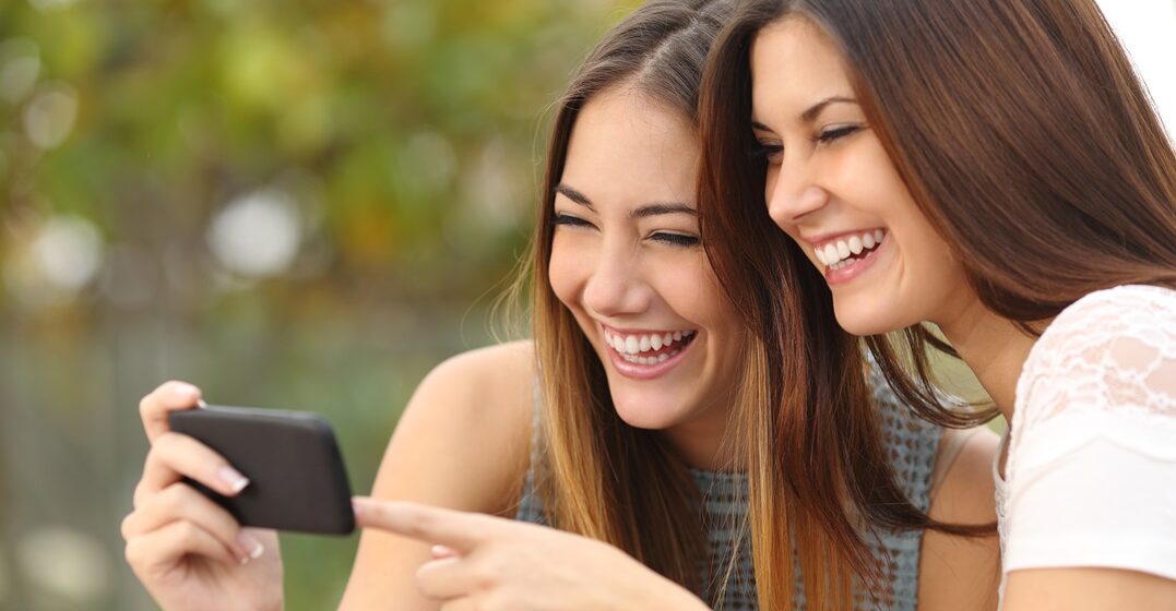 Zwei junge Frauen gucken sich die besten deutschen Beleidigungen an