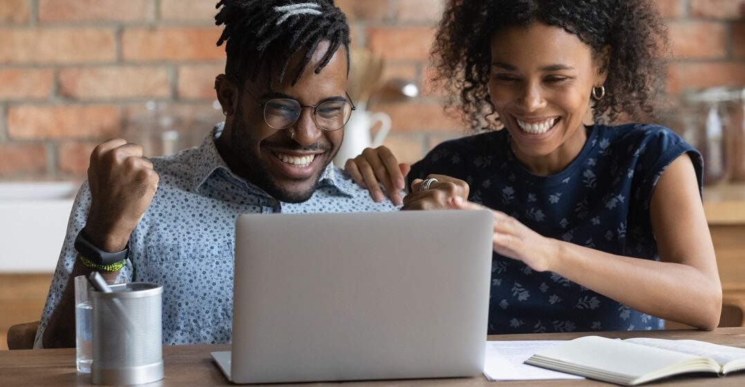 Close,Up,Overjoyed,African,American,Couple,Looking,At,Laptop,Screen