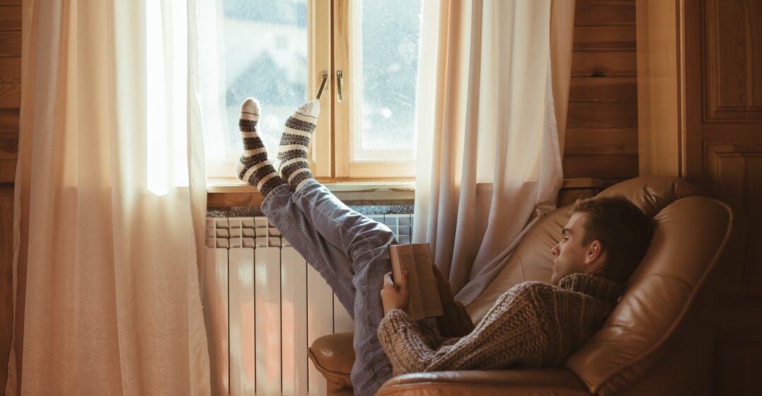 Young,Man,In,Warm,Sweater,Reading,Book,While,Relaxing,On