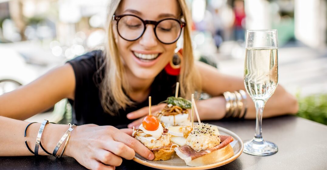 Young,Woman,Enjoying,Tasty,Appetizer,With,Pinchos,,Traditional,Spanish,Snack,