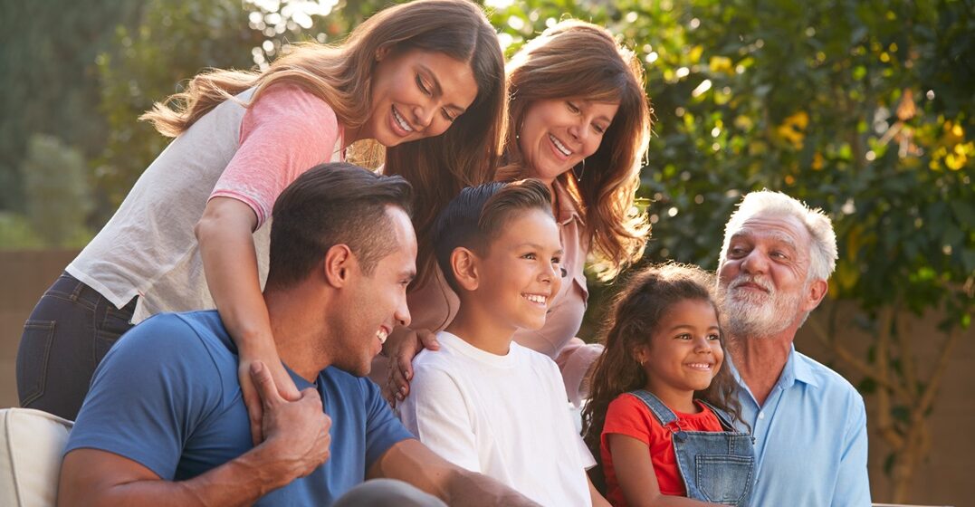 Multi-generation,Hispanic,Family,Relaxing,In,Garden,At,Home,Together